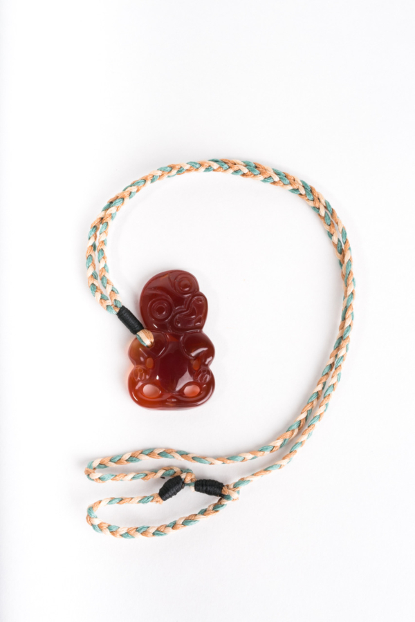 Hei Tiki, Red carnelian on cream/natural/green cord