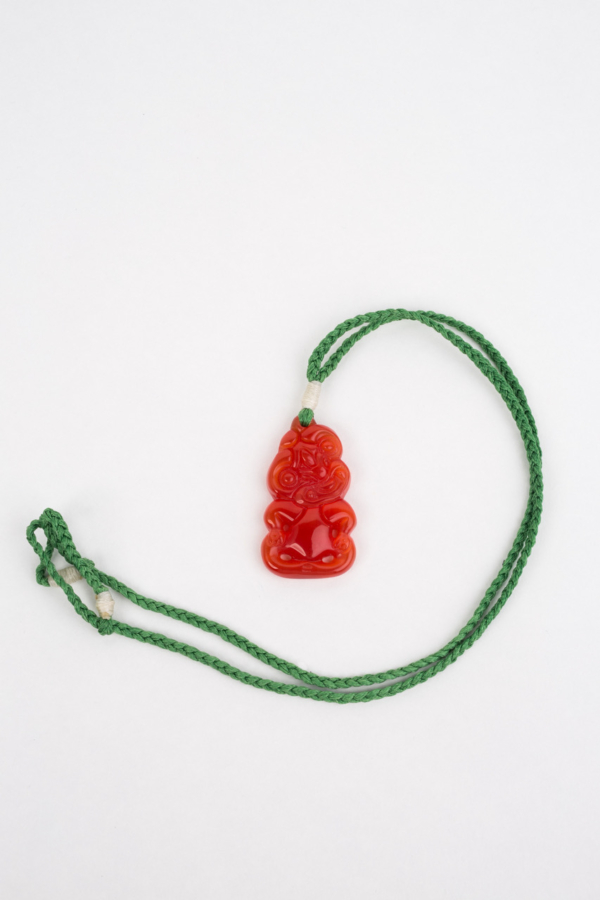 Hei Tiki, Orange beryl on green cord